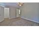 Large, carpeted bedroom featuring neutral paint, a ceiling fan, and access to the ensuite bathroom at 4120 Buckley Woods Dr, Norcross, GA 30093