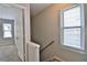 Bright hallway featuring neutral walls, a staircase, a window and an open door to a bedroom at 4120 Buckley Woods Dr, Norcross, GA 30093