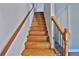 A bright staircase with wood stairs, handrails and iron balusters leads to the upper level of the home at 4120 Buckley Woods Dr, Norcross, GA 30093