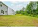 A vast, grassy backyard with newly laid sod, bordering a lush wooded area, and a view of the house at 174 Bloomfield Cir, Canton, GA 30114