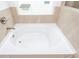 Close-up of a bathtub with tile surround and a window for natural light at 174 Bloomfield Cir, Canton, GA 30114
