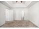 Bright bedroom featuring tray ceilings, neutral walls, closet doors, and an ensuite bathroom at 3694 Arrowhead Pl, Douglasville, GA 30135