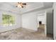 Spacious bedroom with tray ceiling, ample natural light, and view to the living room with fireplace at 3694 Arrowhead Pl, Douglasville, GA 30135