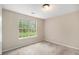 Bright bedroom featuring neutral walls and a large window overlooking the landscape at 3694 Arrowhead Pl, Douglasville, GA 30135