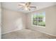 Light filled bedroom featuring neutral walls, a ceiling fan, and a window overlooking the landscape at 3694 Arrowhead Pl, Douglasville, GA 30135
