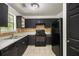 Kitchen featuring tile floors, sleek black appliances, and plenty of cabinet space at 3694 Arrowhead Pl, Douglasville, GA 30135
