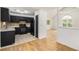 View of black kitchen with appliances, tile backsplash, and a layout that extends to the living area at 3694 Arrowhead Pl, Douglasville, GA 30135