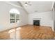 Open living room with a fireplace, hardwood floors, and a large window at 3694 Arrowhead Pl, Douglasville, GA 30135