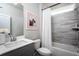 Cozy bathroom with gray vanity, tub with white curtain and gray tile walls at 5121 Hillside Haven Drive, Powder Springs, GA 30127
