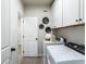 Functional laundry room with white cabinets, a washer and dryer, and stylish decor at 5121 Hillside Haven Drive, Powder Springs, GA 30127