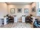 Well-lit home office with dual desks, modern decor, and a cozy reading nook at 5121 Hillside Haven Drive, Powder Springs, GA 30127