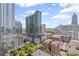 An aerial view showcasing modern high rises and buildings in an urban area surrounded by lush green trees at 860 Peachtree Ne St # 1712, Atlanta, GA 30308