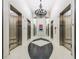 A stylish lobby features elevators and custom floors with a decorative lighting fixture and a mirror at 860 Peachtree Ne St # 1712, Atlanta, GA 30308