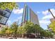 An exterior of the condo tower with lush trees and clear blue skies at 860 Peachtree Ne St # 1712, Atlanta, GA 30308