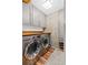 This is a modern laundry room featuring gray cabinets, wood countertop, and a stainless steel washer and dryer at 860 Peachtree Ne St # 1712, Atlanta, GA 30308