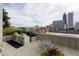 A rooftop deck with stainless steel grills, a dining table, and city views for outdoor living and entertaining at 860 Peachtree Ne St # 1712, Atlanta, GA 30308