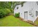Lawn of home featuring the side entrance to the basement, foliage, and a partial fence at 1118 Creekdale Dr, Clarkston, GA 30021