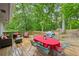 Wooden backyard deck featuring outdoor dining table, seating area, and wooded view at 1118 Creekdale Dr, Clarkston, GA 30021