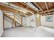 Unfinished basement with exposed ceiling beams, and access to upper levels at 1118 Creekdale Dr, Clarkston, GA 30021