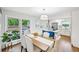 Bright dining room with modern furnishings, hardwood floors, and an open view to the kitchen and deck at 1118 Creekdale Dr, Clarkston, GA 30021