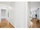 Hallway with hardwood floors leads to bright dining room and other rooms at 1118 Creekdale Dr, Clarkston, GA 30021