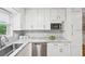 Well-lit kitchen featuring stainless steel appliances, marble countertops, and stylish white cabinets at 1118 Creekdale Dr, Clarkston, GA 30021