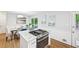 Well-lit kitchen featuring a stainless steel oven and cooktop, marble countertops, and hardwood floors at 1118 Creekdale Dr, Clarkston, GA 30021