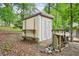 Backyard shed with convenient ramp, shelving, and adjacent wood storage enhancing outdoor utility at 1118 Creekdale Dr, Clarkston, GA 30021