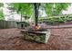 Backyard featuring a stone fire pit, wooden dog house, and black metal fence at 4910 Bucknell Trce, Cumming, GA 30028