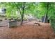 Landscaped backyard featuring a fire pit, storage shed, and lush greenery at 4910 Bucknell Trce, Cumming, GA 30028