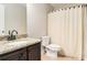 Bathroom featuring granite countertop, dark wood cabinets and a shower with beige striped curtain at 4910 Bucknell Trce, Cumming, GA 30028