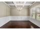 Formal dining room featuring elegant chandelier, coffered ceiling, and wainscoting at 4910 Bucknell Trce, Cumming, GA 30028