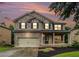 Two-story brick home featuring manicured landscaping, a two-car garage, and a covered front porch at 4910 Bucknell Trce, Cumming, GA 30028