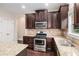 Kitchen features stainless steel appliances, granite countertops and dark wood cabinets at 4910 Bucknell Trce, Cumming, GA 30028