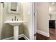Charming powder room with pedestal sink and decorative mirror and hardwood floors at 4910 Bucknell Trce, Cumming, GA 30028