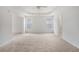 Spacious bedroom with carpet, a tray ceiling with fan, and light from two windows at 7280 Wright Dr, Atlanta, GA 30349