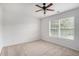 A bright bedroom has carpet, a ceiling fan and natural light with a large window and mini blinds at 7280 Wright Dr, Atlanta, GA 30349