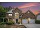 Front exterior of a brick two-story home with a two-car garage and manicured landscaping at 7280 Wright Dr, Atlanta, GA 30349