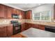 Functional kitchen featuring wooden cabinetry, black appliances, and a practical island, ideal for cooking at 7280 Wright Dr, Atlanta, GA 30349