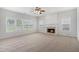 Spacious living room with multiple windows, a ceiling fan, a fireplace, and neutral carpet at 7280 Wright Dr, Atlanta, GA 30349