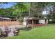 A spacious backyard with a fire pit, patio, and lush green grass with mature trees at 96 Dartmouth Ave, Avondale Estates, GA 30002