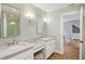 Bathroom with marble counters, dual sinks, decorative mirror, and modern lighting fixtures at 96 Dartmouth Ave, Avondale Estates, GA 30002