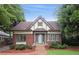 Charming Tudor home with brick facade, symmetrical windows, manicured landscaping and a tiled front walkway at 96 Dartmouth Ave, Avondale Estates, GA 30002