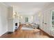 Cozy living room with fireplace, neutral walls, wood floors, and bright, natural lighting from large windows at 96 Dartmouth Ave, Avondale Estates, GA 30002