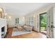 Bright living room with hardwood floors, shutters, fireplace and a view to the outside, complemented with neutral decor at 96 Dartmouth Ave, Avondale Estates, GA 30002