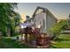 Evening view of the backyard featuring a wooden deck and stone patio area at 222 Mossy Pl, Alpharetta, GA 30005