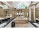 Beautiful bathroom with a jetted tub, granite countertops, mirrors, and high ceilings at 222 Mossy Pl, Alpharetta, GA 30005