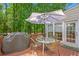 Relaxing deck area features a table, umbrella, chairs, and a grill at 222 Mossy Pl, Alpharetta, GA 30005