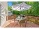 Relaxing deck area features a table, umbrella, chairs, and a grill at 222 Mossy Pl, Alpharetta, GA 30005