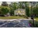Lovely two-story home with a well-manicured lawn, mature trees, and a circular driveway at 222 Mossy Pl, Alpharetta, GA 30005